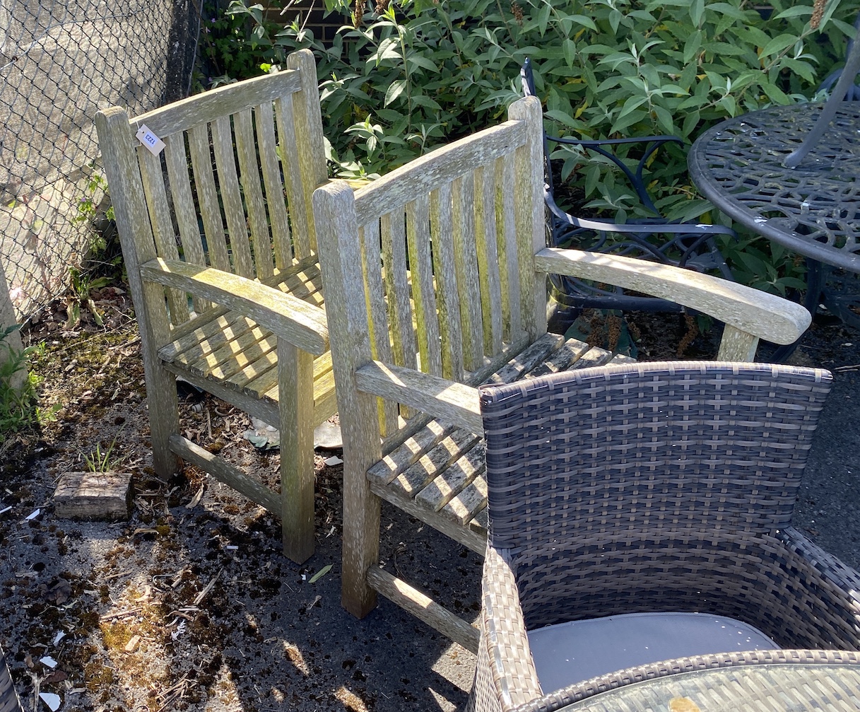 A pair of weathered teak garden elbow chairs, width 71cm, height 96cm